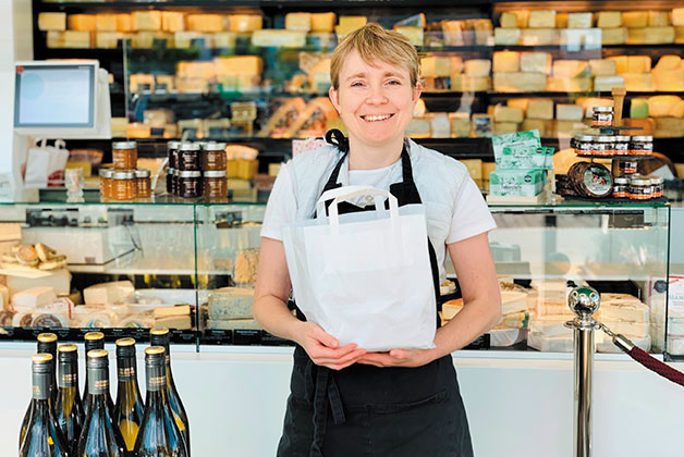 Anna halt eine Käsetüte in der Hand