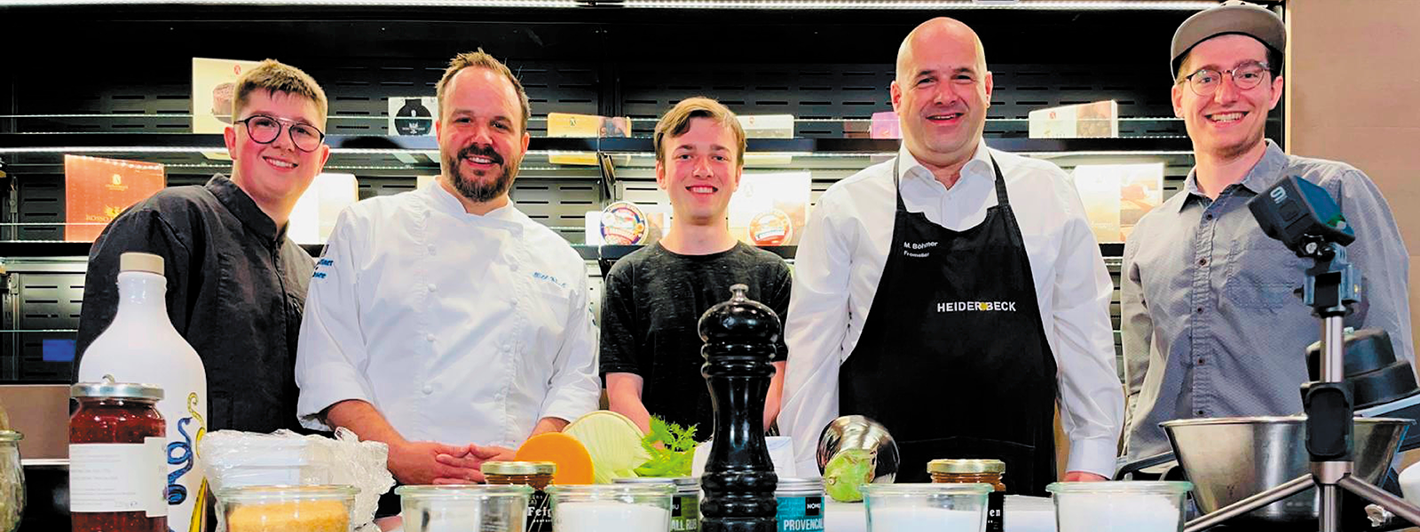 Das Team von Kochen mit Käse posiert an der Theke der Heiderbeck Akademie