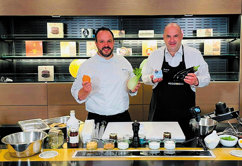 Marcus Böhmer und Till Weiß posieren an der Theke der Heiderbeck Akademie