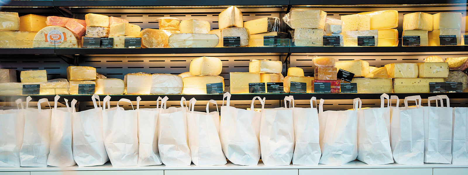 Käse-Überraschungstüten stehen aufgereiht an der Theke des Käse-Outlets.