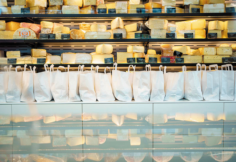 Käsetüten stehen aneinandergereiht auf der Theke des Outlets.