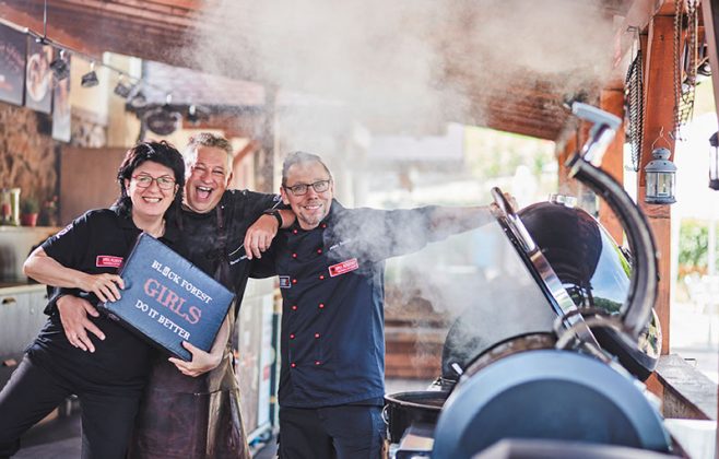 Das Team von Forum Culinaire präsentiert sich vor einem brennenden Grill