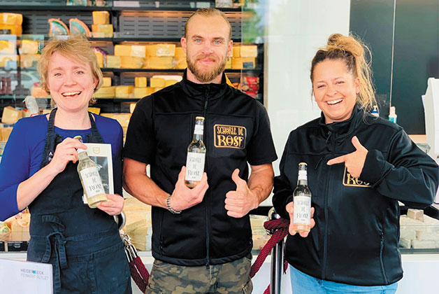 Anna und ein Herr und eine Dame präsentieren die Schorle de Rose im Heiderbeck Feinkost Outlet